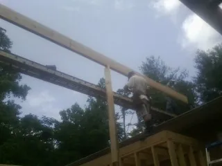 Carpenter setting a ridge beam over a new addition frame — Ice Dam Removal by Roofing Brothers in Mineral Wells