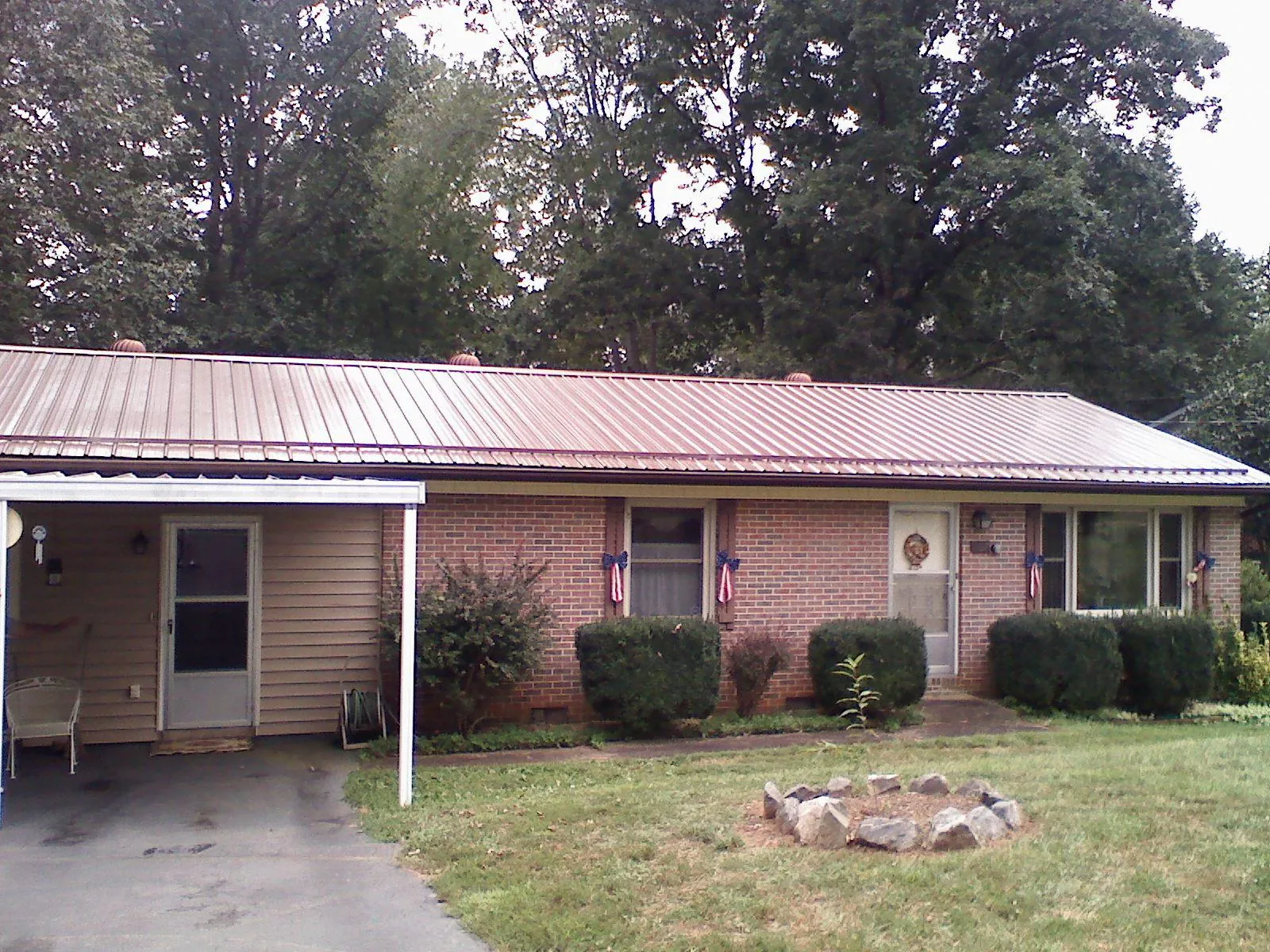 Bronze metal roof and carport on a brick ranch home — Roof Repair work by our crew in Mineral Wells
