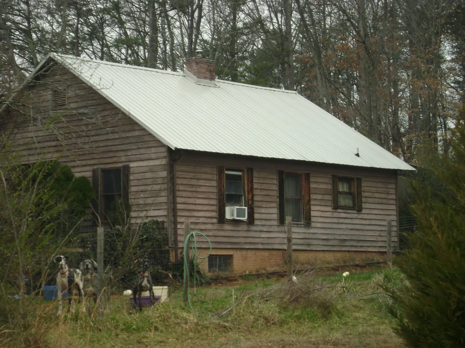 White metal roof on an old wood sided farmhouse, from a Metal Roof Installation job in Mineral Wells